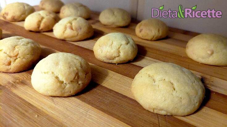 Biscotti al cioccolato bianco disposti su una tavola di legno, pronti da gustare.