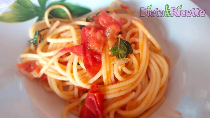 Spaghetti con pomodorini, basilico e aglio in un piatto bianco